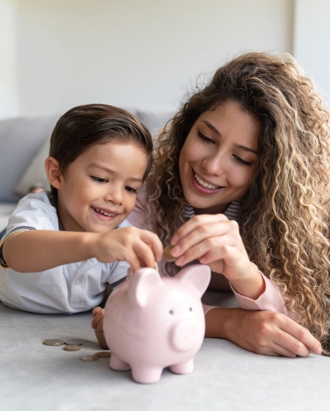 Child putting money in piggybank